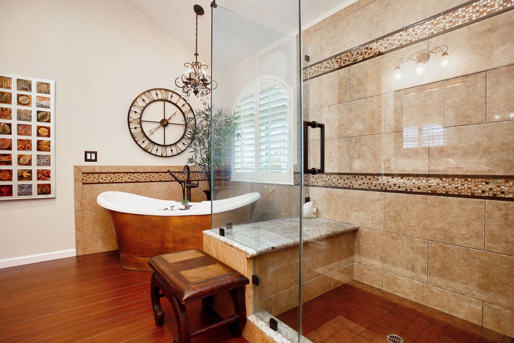 Sizeable walk-in shower with decorative tile detail.