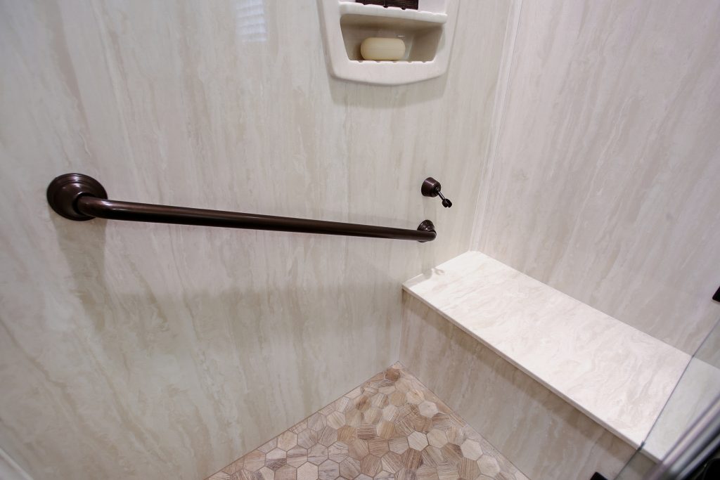 Formerly a tub that we transformed into a walk-in shower with bench and grab bar for comfort and easy accessibility.