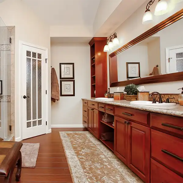 White bathroom with stone floor and clear glass shower and white geometric tub