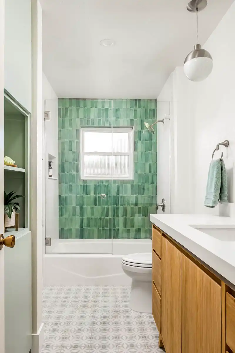 White bathroom with green tile subtle mosaic in the tub-shower; green accents