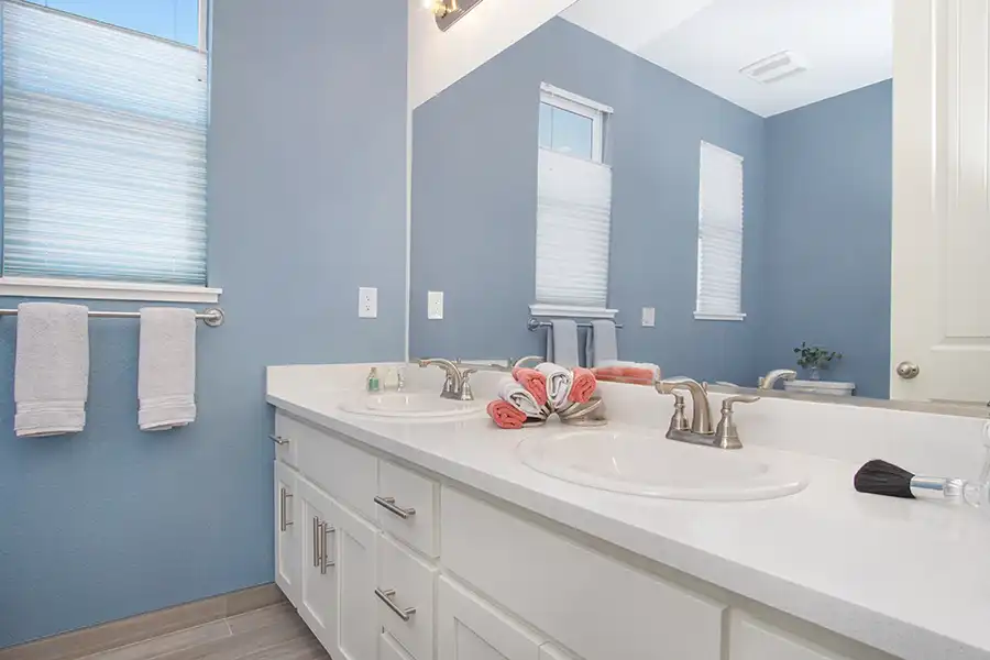 O2 MAYNARD Bath After 1 Dark hardwood flooring, white cabinets, matte black hardware and fixtures, stainless steel hood, gas range, dark gray island with banquette, small glass top dining table, coffered ceilings