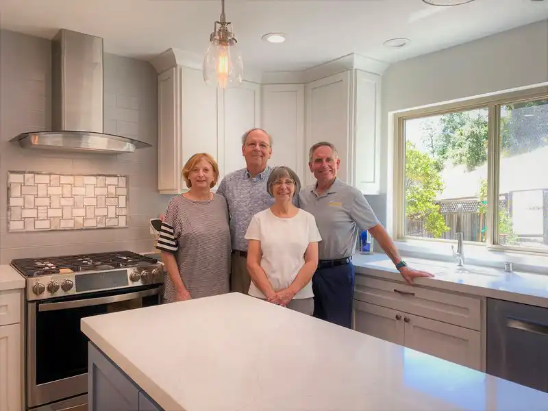 James Carey in white-neutral kitchen with happy customers