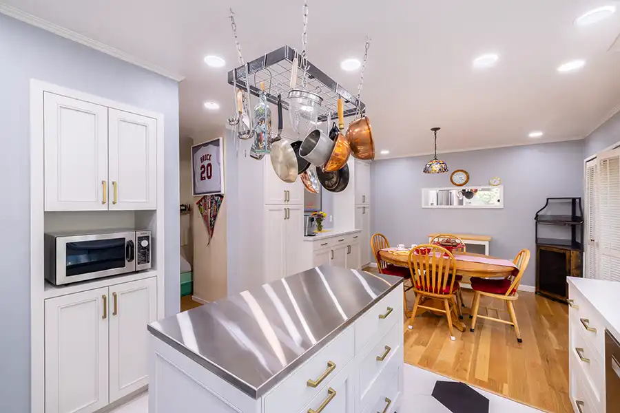 White bathroom with stone floor and clear glass shower and white geometric tub