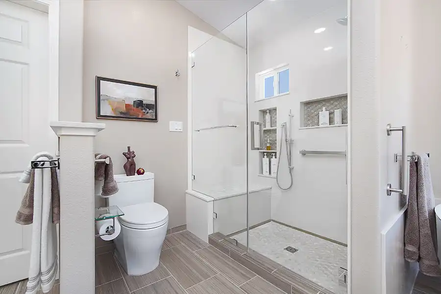 010_5558_Arlene_way4 Creamy almond walls, light-toned wood cabinets with modern hardware, light colored stone countertops with twin sinks, a soaking tub in the corner by a window, with a glass-surround shower in the opposing corner, and wood motif tile on the floors.