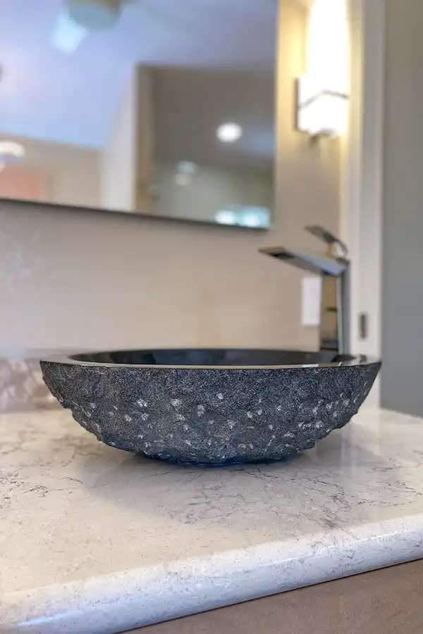 015_5558_Arlene_way20 Creamy almond walls, light-toned wood cabinets with modern hardware, light colored stone countertops with twin sinks, a soaking tub in the corner by a window, with a glass-surround shower in the opposing corner, and wood motif tile on the floors.