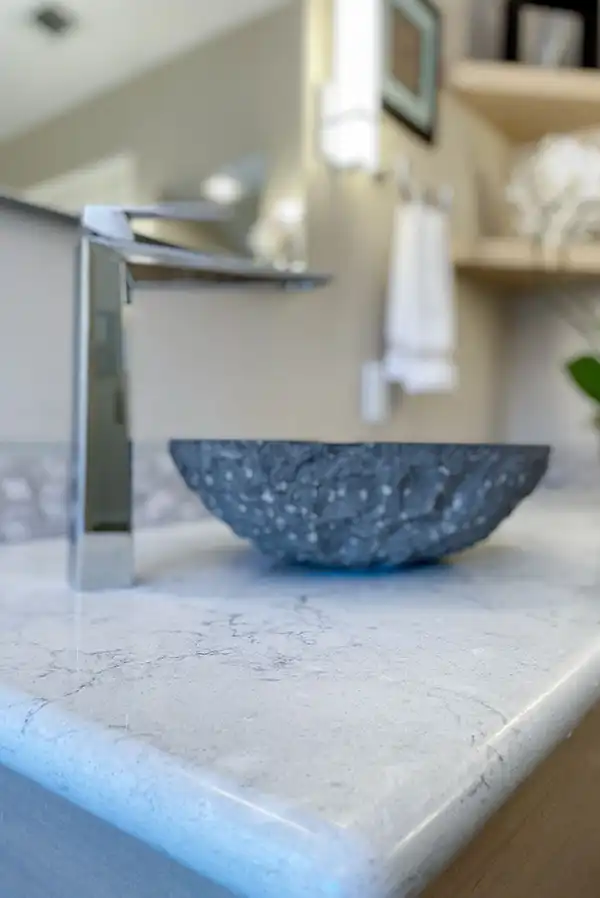 021_5558_Arlene_way18 Creamy almond walls, light-toned wood cabinets with modern hardware, light colored stone countertops with twin sinks, a soaking tub in the corner by a window, with a glass-surround shower in the opposing corner, and wood motif tile on the floors.