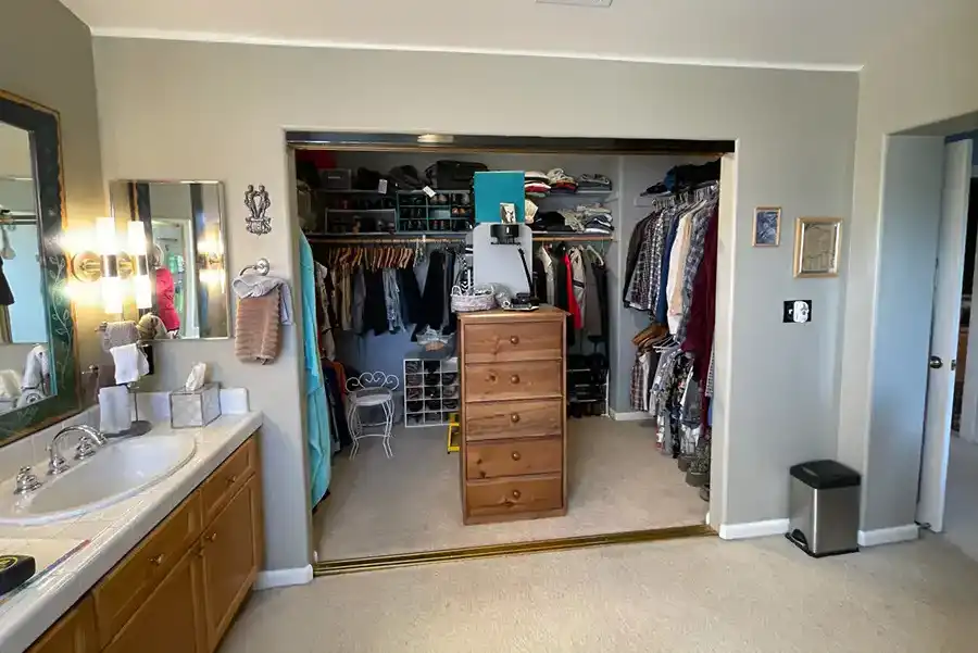 05.2 BEFORE ARLENE IMG_0357 taupe walls, medium-toned wood cabinets, white tile countertops with twin sinks, soaking tub in corner by window, with shower in opposing corner.