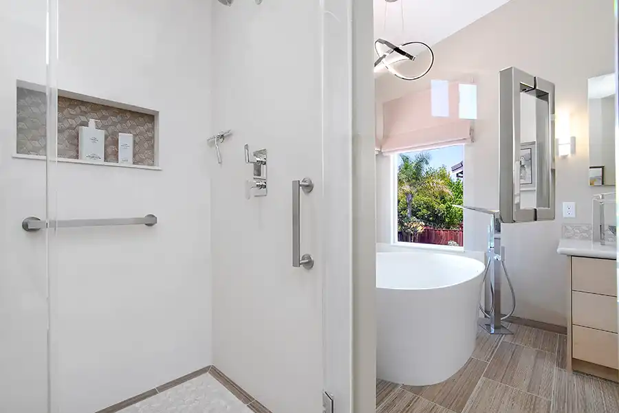 09_5558_Arlene_way5 Creamy almond walls, light-toned wood cabinets with modern hardware, light colored stone countertops with twin sinks, a soaking tub in the corner by a window, with a glass-surround shower in the opposing corner, and wood motif tile on the floors.